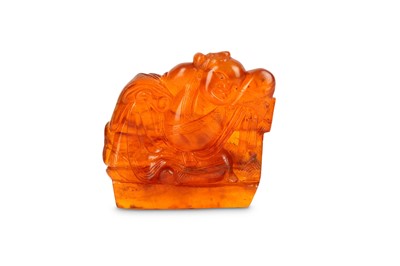 Lot 425 - A CHINESE AMBER CARVING OF A BOY. Qing Dynasty....