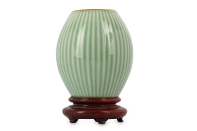 Lot 206 - A CHINESE CELADON VASE. The body moulded along...