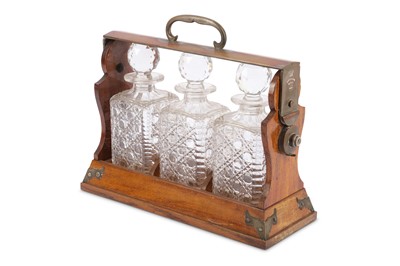 Lot 235 - An Edwardian oak three bottle tantalus, fitted...