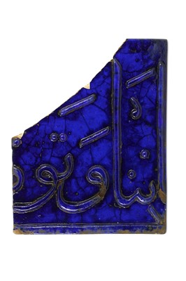 Lot 123 - A FRAGMENTARY BLUE-GLAZED LAJVARDINA CALLIGRAPHIC POTTERY TILE