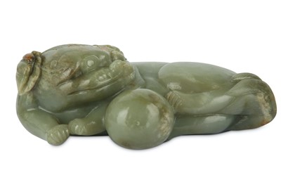 Lot 501 - A CHINESE PALE CELADON CARVING OF A LION DOG WITH A BALL, 20TH CENTURY