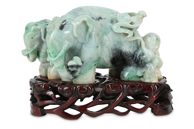 Lot 353 - A CHINESE APPLE-GREEN JADEITE 'ELEPHANTS AND A BOYS' GROUP.