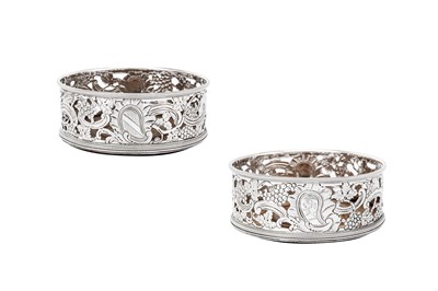 Lot 572 - A pair of George III Irish sterling silver wine coasters, Dublin circa 1760 by Andrew Goodwin (free 1730, died 1787)