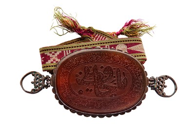 Lot 235 - A SILK SWADDLING BAND AND A FINELY ENGRAVED CARNELIAN BAZUBAND PENDANT