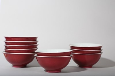Lot 74 - A SET OF TEN CHINESE COPPER RED-GLAZED BOWLS.