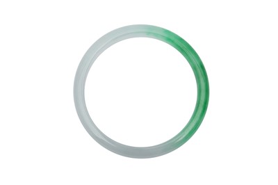 Lot 698 - A CHINESE APPLE-GREEN JADEITE BANGLE.