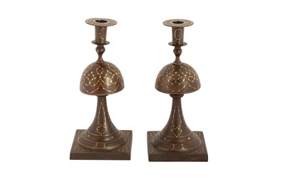 Lot 240 - A PAIR OF QAJAR GOLD-DAMASCENED STEEL CANDLESTICKS