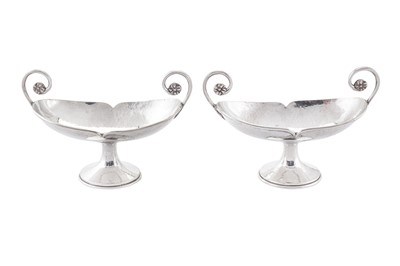 Lot 263 - A pair of George V 'Arts and Crafts' sterling silver twin handled pedestal dishes, London 1912 by A. E. Jones
