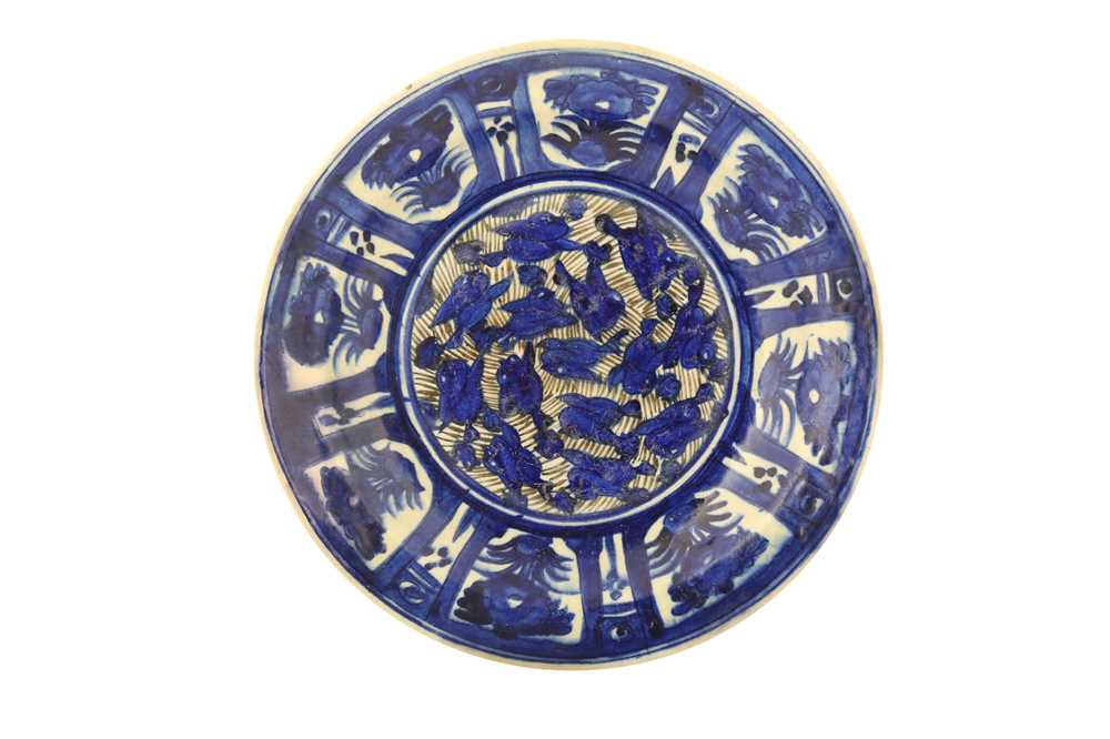 Lot 80 - A LARGE LATE QAJAR BLUE AND WHITE POTTERY CHARGER