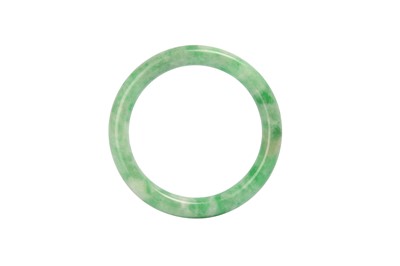 Lot 625 - A CHINESE APPLE-GREEN JADEITE BANGLE.
