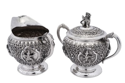 Lot 185 - An early 20th century Burmese unmarked silver milk jug and covered twin handled sugar bowl, Thayetmyo circa 1900