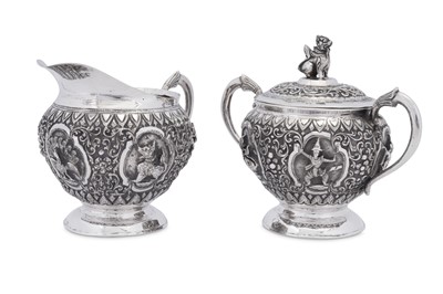 Lot 185 - An early 20th century Burmese unmarked silver milk jug and covered twin handled sugar bowl, Thayetmyo circa 1900