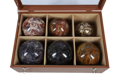 Lot 548 - A CASED SET OF SIX SPECIMEN HARDSTONE SPHERES, 20TH CENTURY