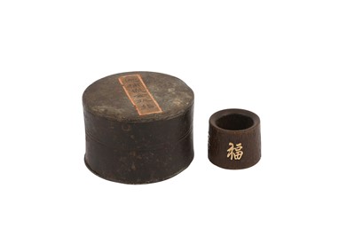 Lot 7 - A CHINESE INSCRIBED AND GOLD-INSET AGARWOOD ARCHER'S RING.