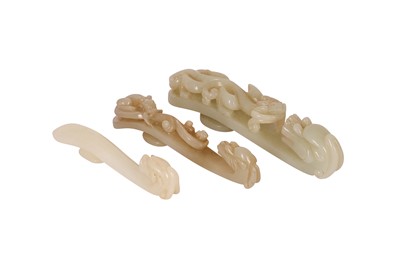 Lot 60 - THREE CHINESE PALE CELADON JADE 'DRAGON' BELT HOOKS.