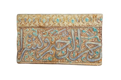 Lot 311 - A KASHAN MOULDED COPPER LUSTRE AND COBALT BLUE CALLIGRAPHIC POTTERY TILE