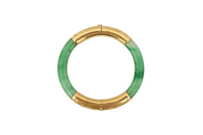 Lot 189 - A CHINESE APPLE-GREEN JADEITE BANGLE.