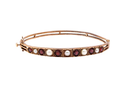 Lot 27 - A GARNET AND PEARL BANGLE