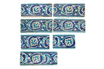Lot 332 - SEVEN IZNIK POTTERY BORDER TILES WITH LOTUS SCROLLS