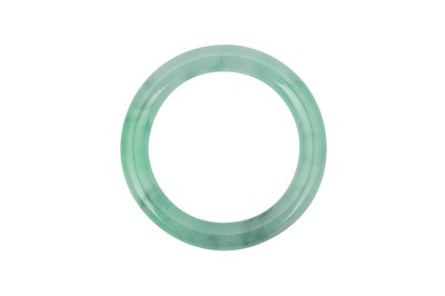 Lot 341 - A CHINESE APPLE-GREEN JADEITE BANGLE.