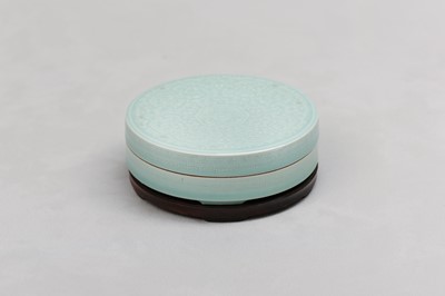 Lot 86 - A CHINESE CELADON-GLAZED CIRCULAR BOX AND COVER.