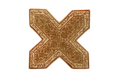 Lot 267 - AN ILKHANID-REVIVAL CROSS-SHAPED COPPER LUSTRE POTTERY TILE
