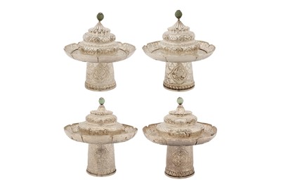 Lot 168 - Two pairs of mid-20th century Tibetan unmarked silver teacup stands and lids