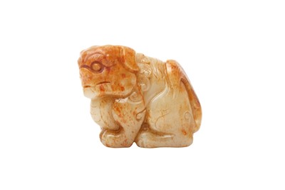 Lot 126 - A CHINESE CELADON AND RUSSET JADE 'LION DOG' CARVING