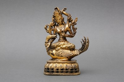 Lot 177 - A SINO-TIBETAN GILT-BRONZE FIGURE OF A FOUR-ARMED BODHISATTVA