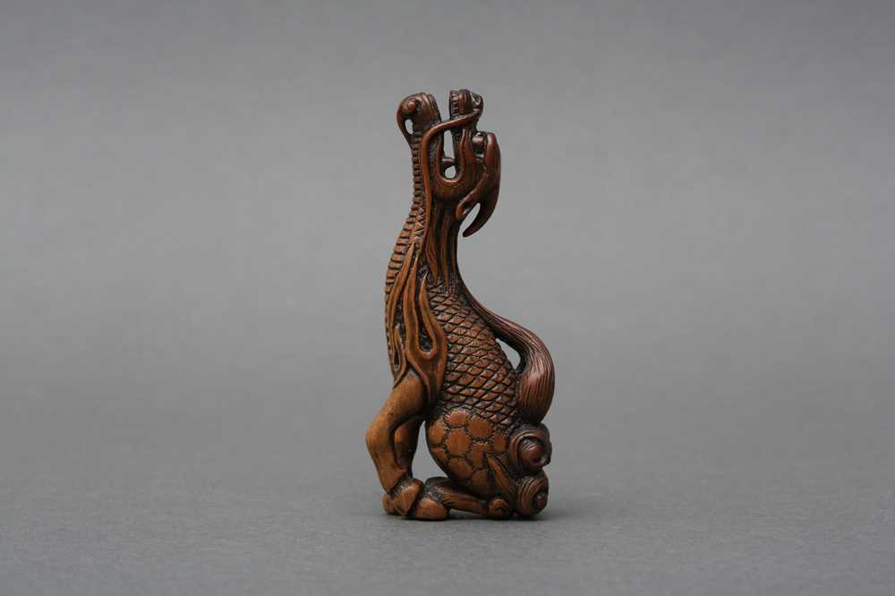 417 - A JAPANESE BOXWOOD NETSUKE OF A MYTHICAL KIRIN, AFTER TOMOTADA