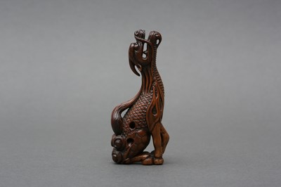 Lot 417 - A JAPANESE BOXWOOD NETSUKE OF A MYTHICAL KIRIN, AFTER TOMOTADA