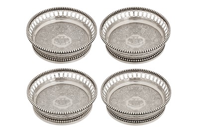 Lot 233 - An interesting and heavy set of four mid-19th century French 950 standard silver bottle stands or wine coasters, Paris post-1838, maker’s mark defaced
