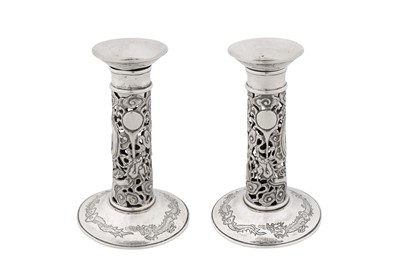 Lot 31 - A pair of early 20th century Chinese export silver candlesticks, Shanghai circa 1920, marked Yu Ji, retailed by Wang Hing