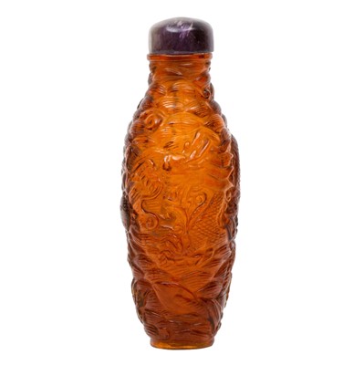 Lot 292 - A Chinese amber coloured glass 'dragon' snuff bottle, 19th century