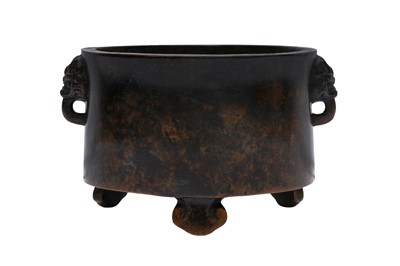 Lot 680 - A CHINESE BRONZE TRIPOD CENSER WITH LION-MASK HANDLES