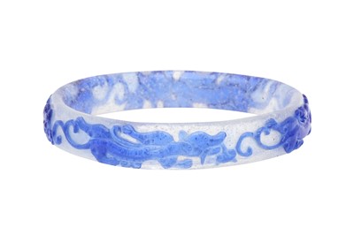 Lot 889 - A CHINESE BLUE-OVERLAY BEIJING GLASS 'CHILONG' BANGLE