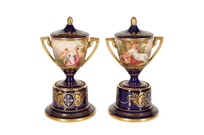 Lot 113 - A PAIR OF SMALL BLUE VIENNA PORCELAIN TWIN HANDLED VASES WITH PAINTED RESERVES