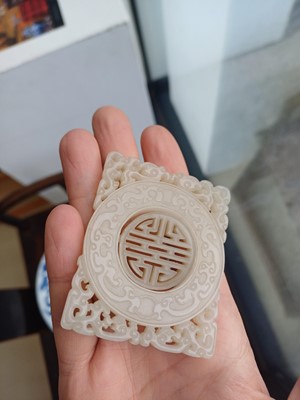 Lot 63 - A CHINESE PALE CELADON JADE RETICULATED 'SHOU' PLAQUE