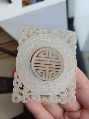 Lot 63 - A CHINESE PALE CELADON JADE RETICULATED 'SHOU' PLAQUE