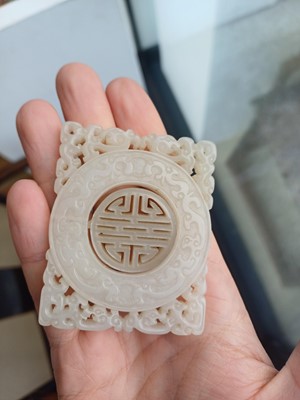 Lot 63 - A CHINESE PALE CELADON JADE RETICULATED 'SHOU' PLAQUE