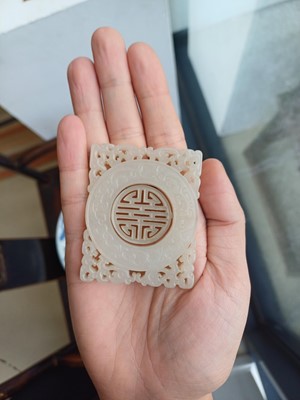 Lot 63 - A CHINESE PALE CELADON JADE RETICULATED 'SHOU' PLAQUE