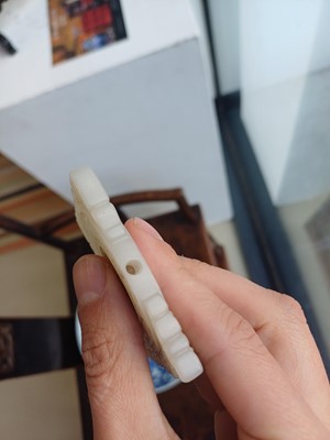 Lot 63 - A CHINESE PALE CELADON JADE RETICULATED 'SHOU' PLAQUE