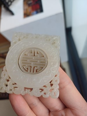 Lot 63 - A CHINESE PALE CELADON JADE RETICULATED 'SHOU' PLAQUE