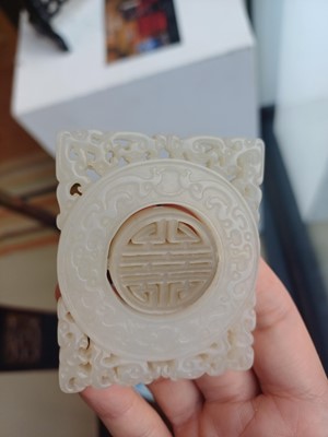 Lot 63 - A CHINESE PALE CELADON JADE RETICULATED 'SHOU' PLAQUE