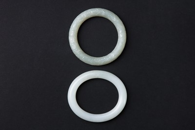 Lot 622 - TWO CHINESE CARVED CELADON JADE BANGLES