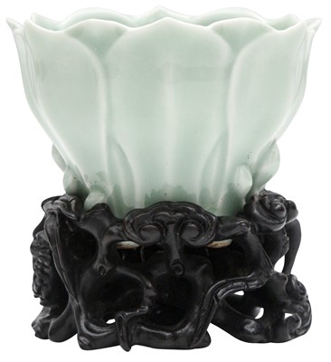 Lot 834 - A CHINESE CELADON GLAZED MAGNOLIA-SHAPED CUP AND WOOD STAND