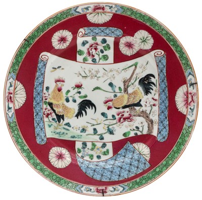 Lot 334 - A CHINESE FAMILLE-ROSE RUBY-GROUND 'ROOSTERS' DISH