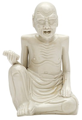 Lot 771 - A CHINESE WHITE-GLAZED FIGURE OF AN EMACIATED LUOHAN