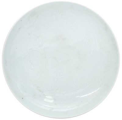 Lot 586 - A CHINESE CELADON-GLAZED INCISED 'DRAGON' DISH