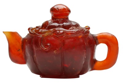 Lot 884 - A CHINESE CARVED AMBER 'CHILONG' TEAPOT AND COVER